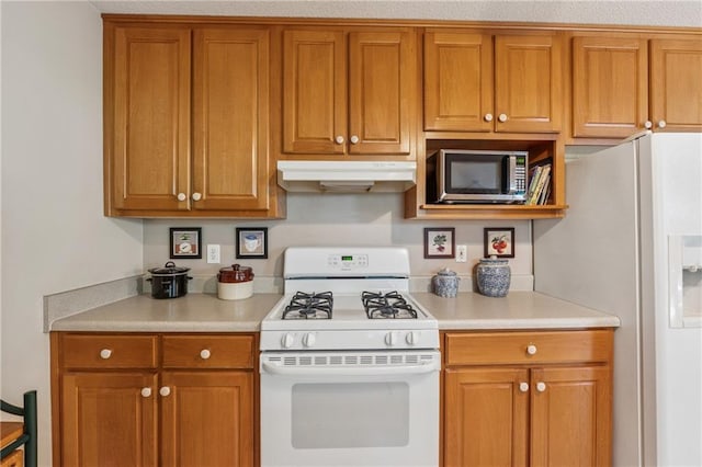 6960 Worley Rd, Cumming, GA 30028 - kitchen with white appliances, under cabinet range hood, light countertops, and brown cabinets