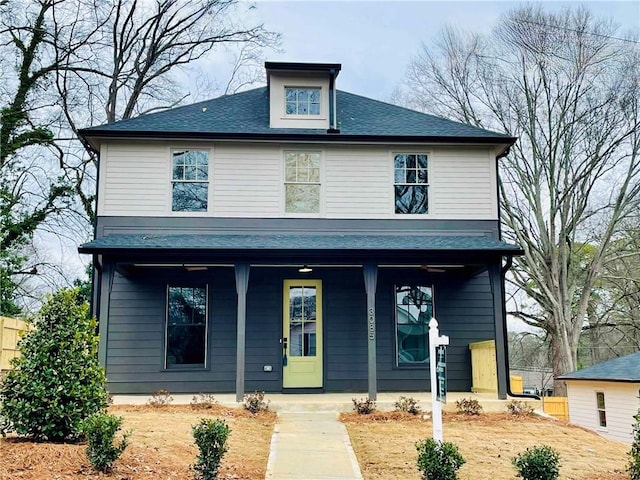 traditional style home with a porch and a shingled roof