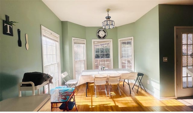 dining area featuring an inviting chandelier, wood finished floors, and baseboards