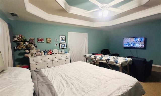 bedroom with carpet floors, a raised ceiling, visible vents, and crown molding