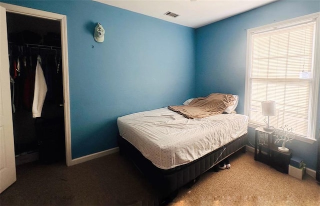 carpeted bedroom with baseboards, a spacious closet, visible vents, and a closet