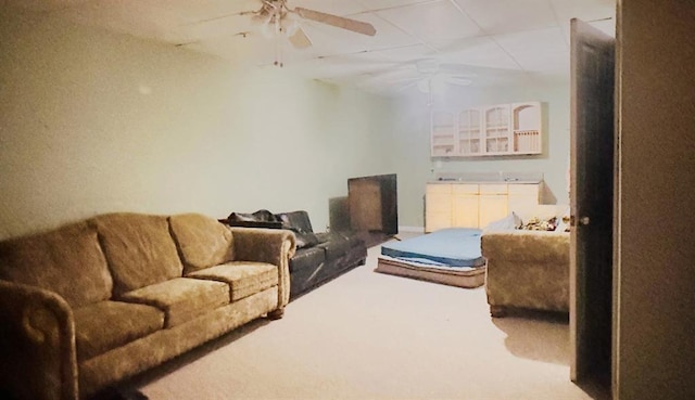 carpeted living area with a ceiling fan