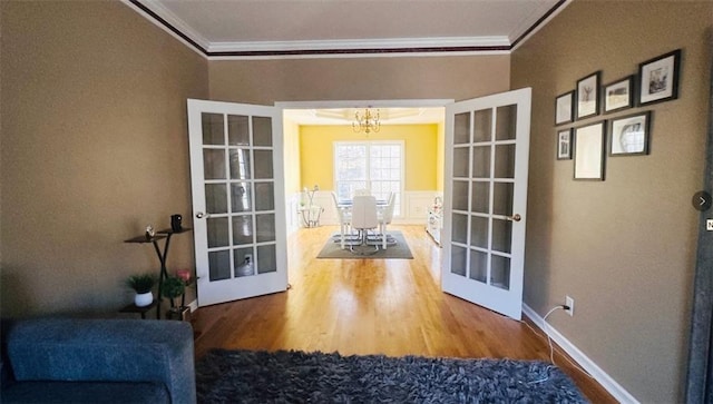 doorway to outside featuring wood finished floors, crown molding, and french doors