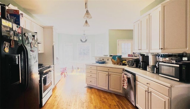 kitchen with light countertops, appliances with stainless steel finishes, light wood-style floors, a sink, and a peninsula