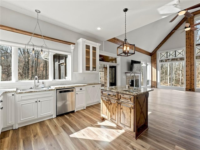 kitchen featuring dishwasher, a sink, glass insert cabinets, and decorative backsplash