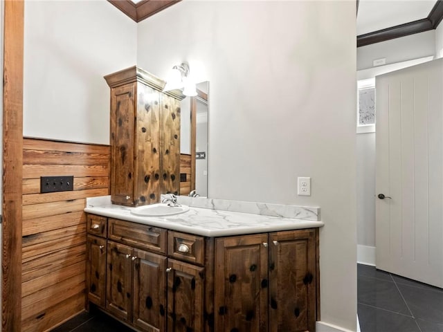 bathroom with wood walls, vanity, ornamental molding, and tile patterned floors