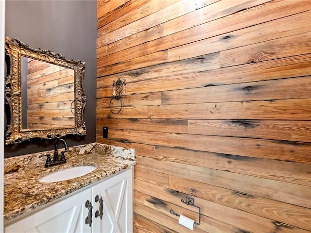 bathroom with wood walls and vanity