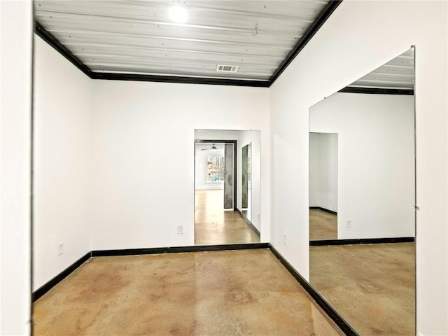 unfurnished room featuring concrete flooring, visible vents, and baseboards