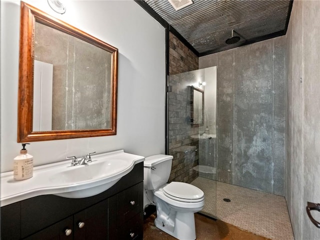 full bath with vanity, a tile shower, and toilet