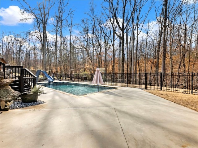 view of pool featuring a fenced in pool, a water slide, a patio area, and fence