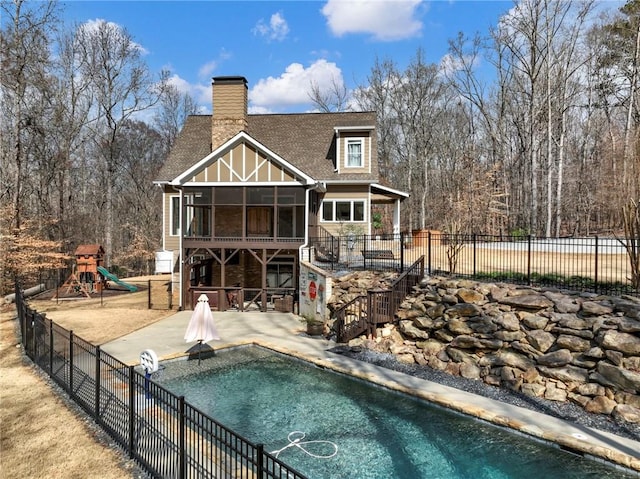 back of house featuring a fenced in pool, a chimney, a sunroom, a patio area, and fence