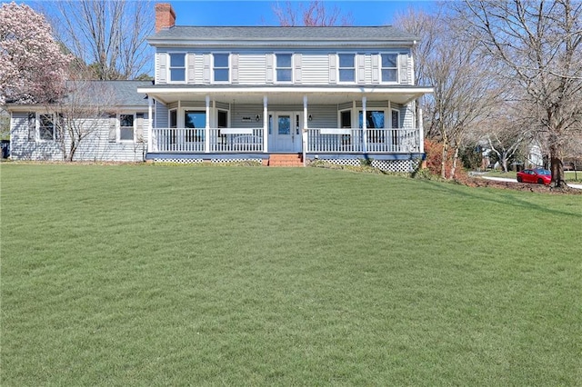 view of front of property with covered porch, a chimney, and a front yard