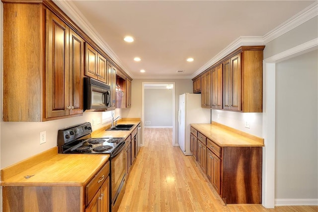 kitchen featuring black appliances, ornamental molding, light wood finished floors, and a sink