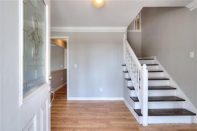 stairs featuring crown molding, baseboards, and wood finished floors