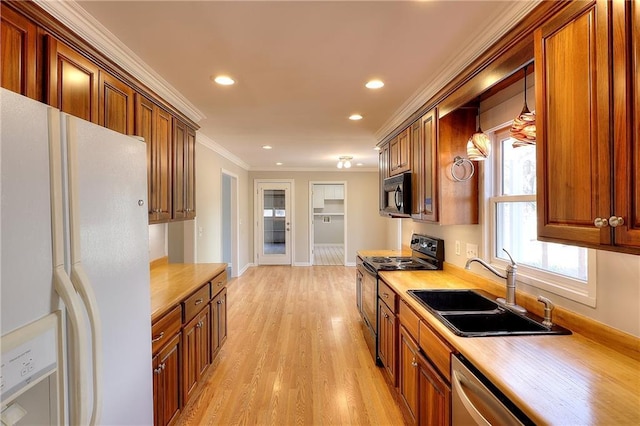 kitchen featuring a sink, appliances with stainless steel finishes, crown molding, and light countertops