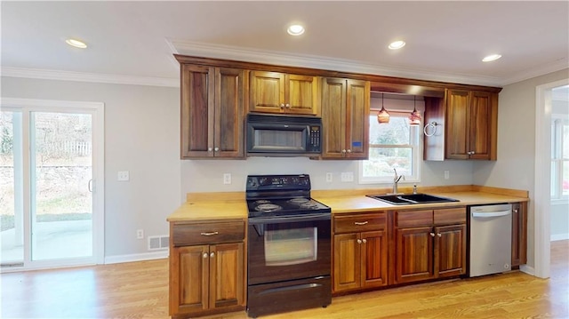 kitchen with a sink, visible vents, black appliances, and ornamental molding