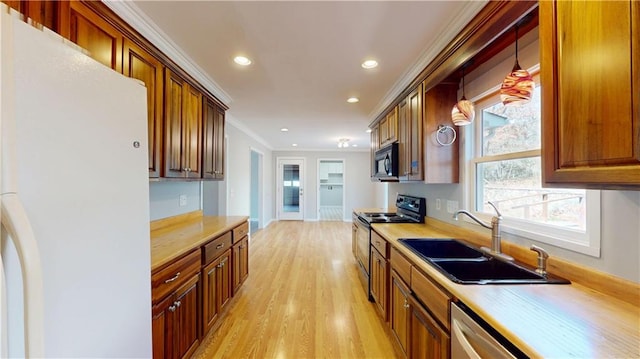 kitchen featuring crown molding, light countertops, recessed lighting, stainless steel appliances, and a sink