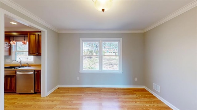 unfurnished dining area with a sink, visible vents, baseboards, and light wood-style flooring