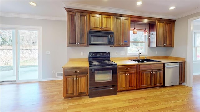 kitchen with visible vents, light wood-style flooring, a sink, black appliances, and crown molding