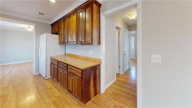 interior space featuring crown molding, light countertops, visible vents, and light wood finished floors