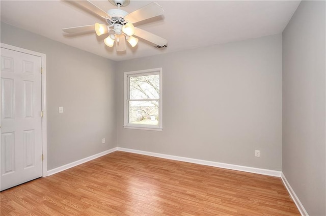 unfurnished room with baseboards, light wood-style floors, and a ceiling fan