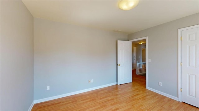 unfurnished bedroom with baseboards and light wood-type flooring