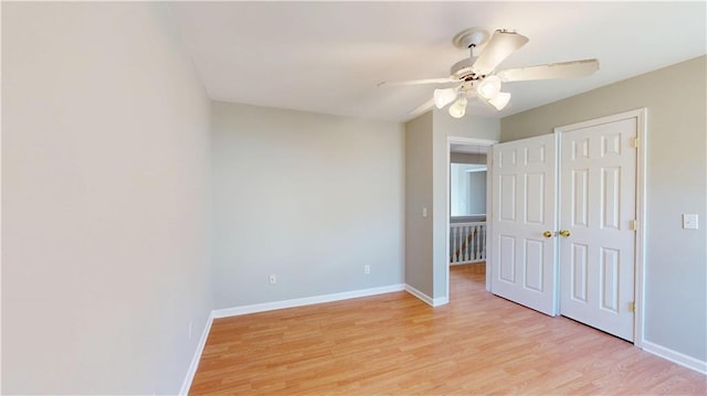 unfurnished bedroom with a closet, baseboards, light wood-style floors, and ceiling fan