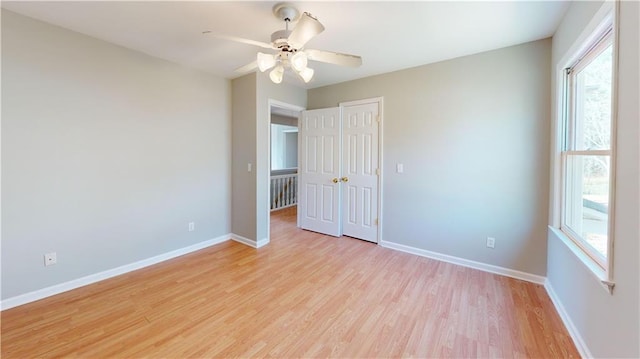 unfurnished bedroom featuring light wood-style floors, baseboards, a closet, and ceiling fan