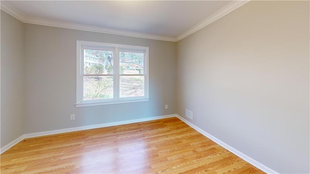 empty room with visible vents, light wood-style flooring, and baseboards