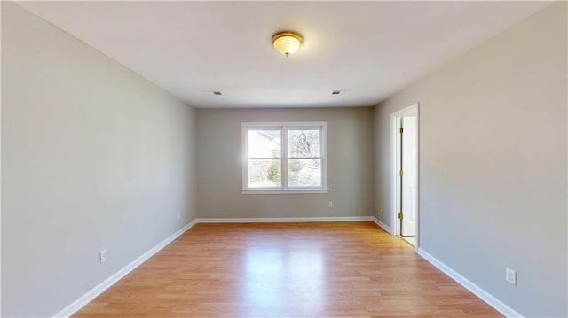 spare room with visible vents, baseboards, and light wood-style floors