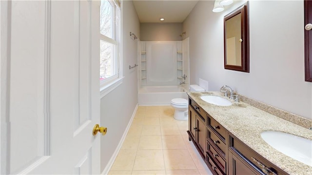 bathroom featuring tile patterned floors, toilet, baseboards, and a sink