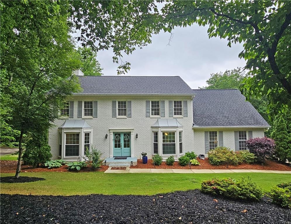 1885 Dayron Trce, Marietta, GA 30062 - colonial home with a front yard, brick siding, a chimney, and roof with shingles