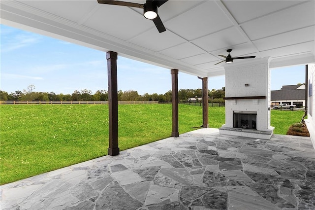 view of patio featuring an outdoor brick fireplace and ceiling fan