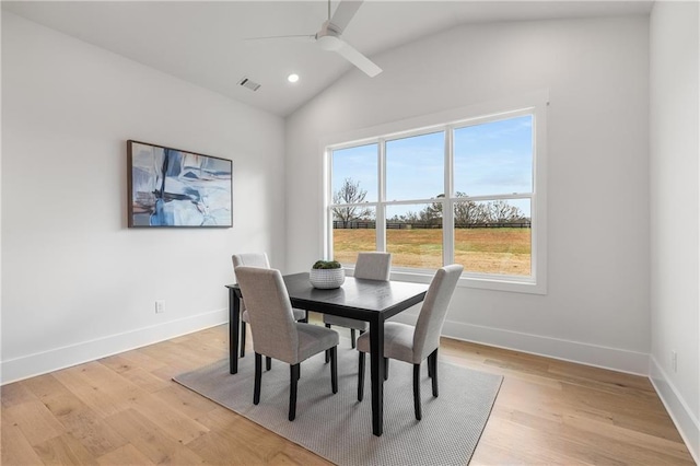 dining area with a healthy amount of sunlight, light hardwood / wood-style flooring, ceiling fan, and lofted ceiling