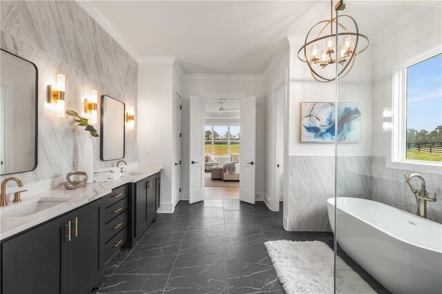 bathroom with a tub, a notable chandelier, vanity, tile walls, and ornamental molding