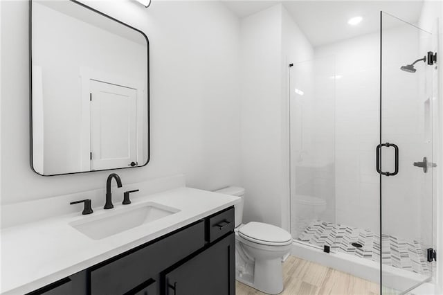 bathroom featuring toilet, vanity, and walk in shower