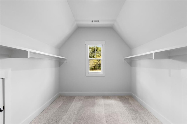 walk in closet featuring carpet and lofted ceiling