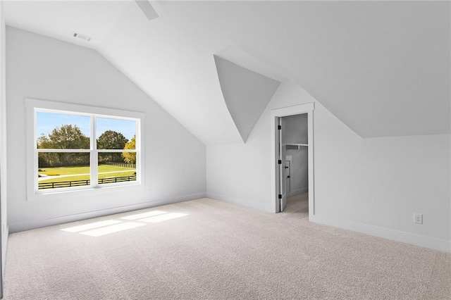 bonus room with light colored carpet and vaulted ceiling