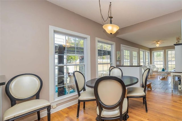 dining room with a healthy amount of sunlight, light wood-style flooring, and baseboards