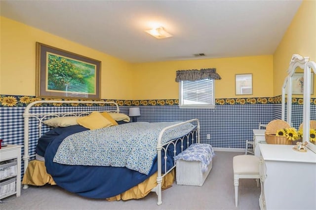 carpeted bedroom with a wainscoted wall