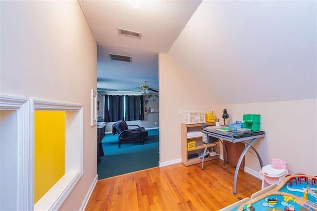 interior space with lofted ceiling, visible vents, baseboards, and wood finished floors