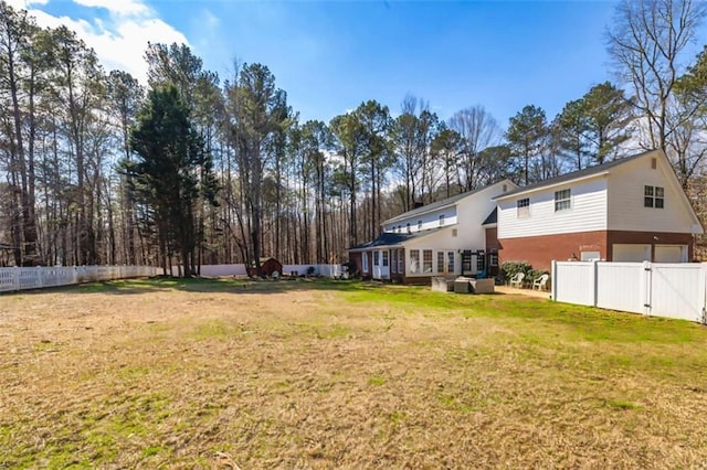 view of yard with an attached garage and fence