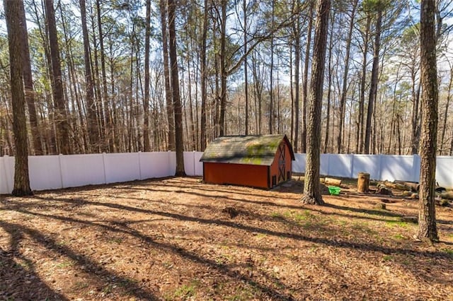 view of yard featuring an outbuilding, a fenced backyard, and a storage unit