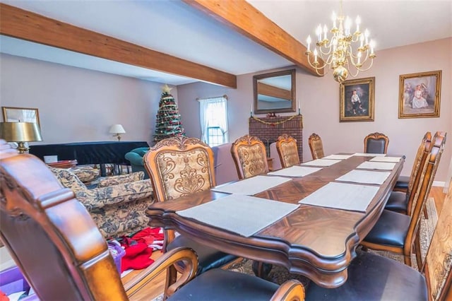 dining space featuring a chandelier, beam ceiling, and wood finished floors