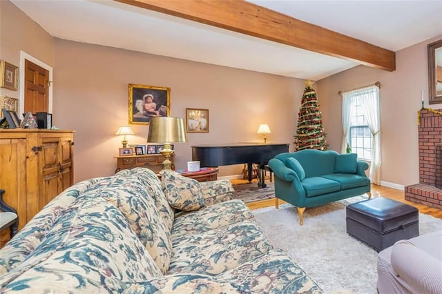 living area with a brick fireplace, baseboards, beamed ceiling, and wood finished floors