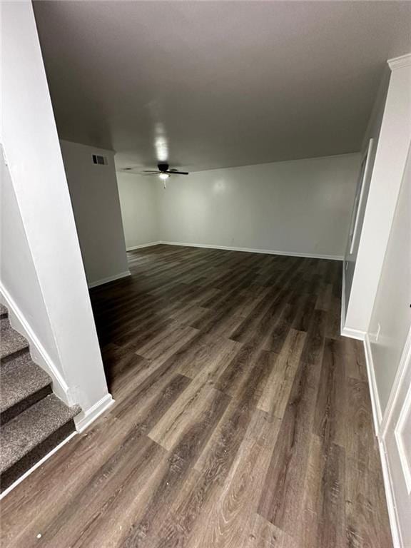 interior space featuring stairs, ceiling fan, dark wood finished floors, and baseboards