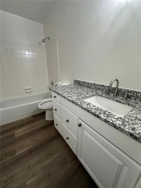 full bath featuring shower / washtub combination, vanity, toilet, and wood finished floors