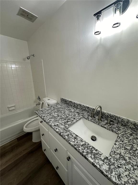 full bathroom with bathing tub / shower combination, visible vents, toilet, vanity, and wood finished floors