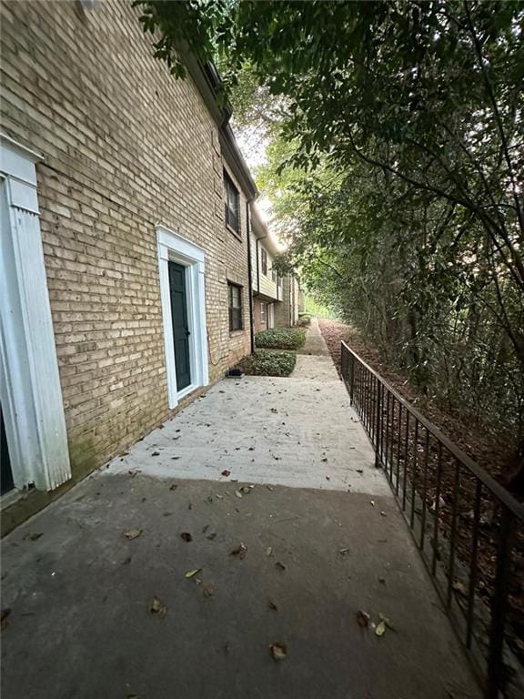 view of side of property featuring a patio and brick siding