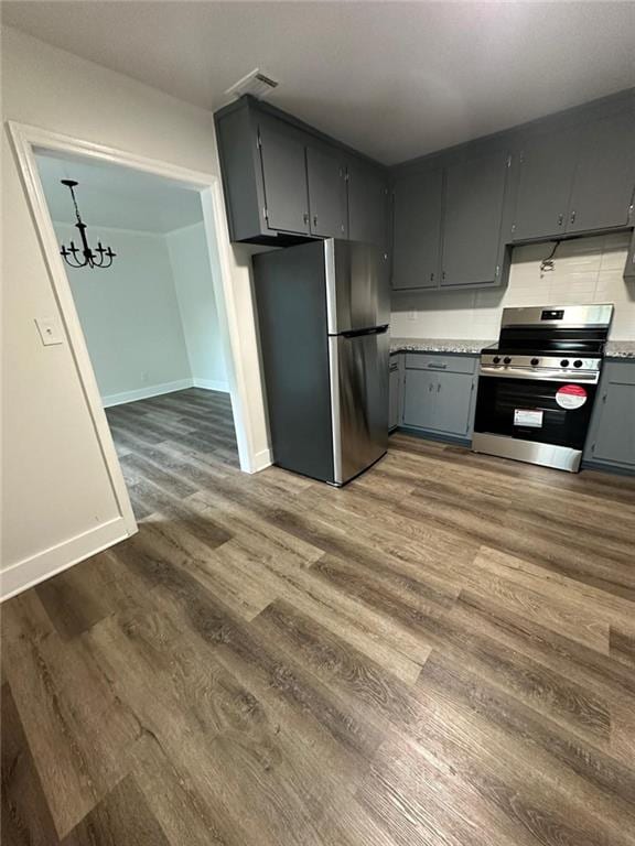 kitchen with stainless steel appliances, dark wood-type flooring, gray cabinets, and light countertops